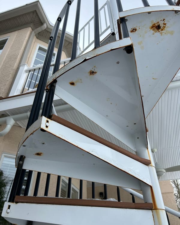 Rusted metal spiral staircase before painting