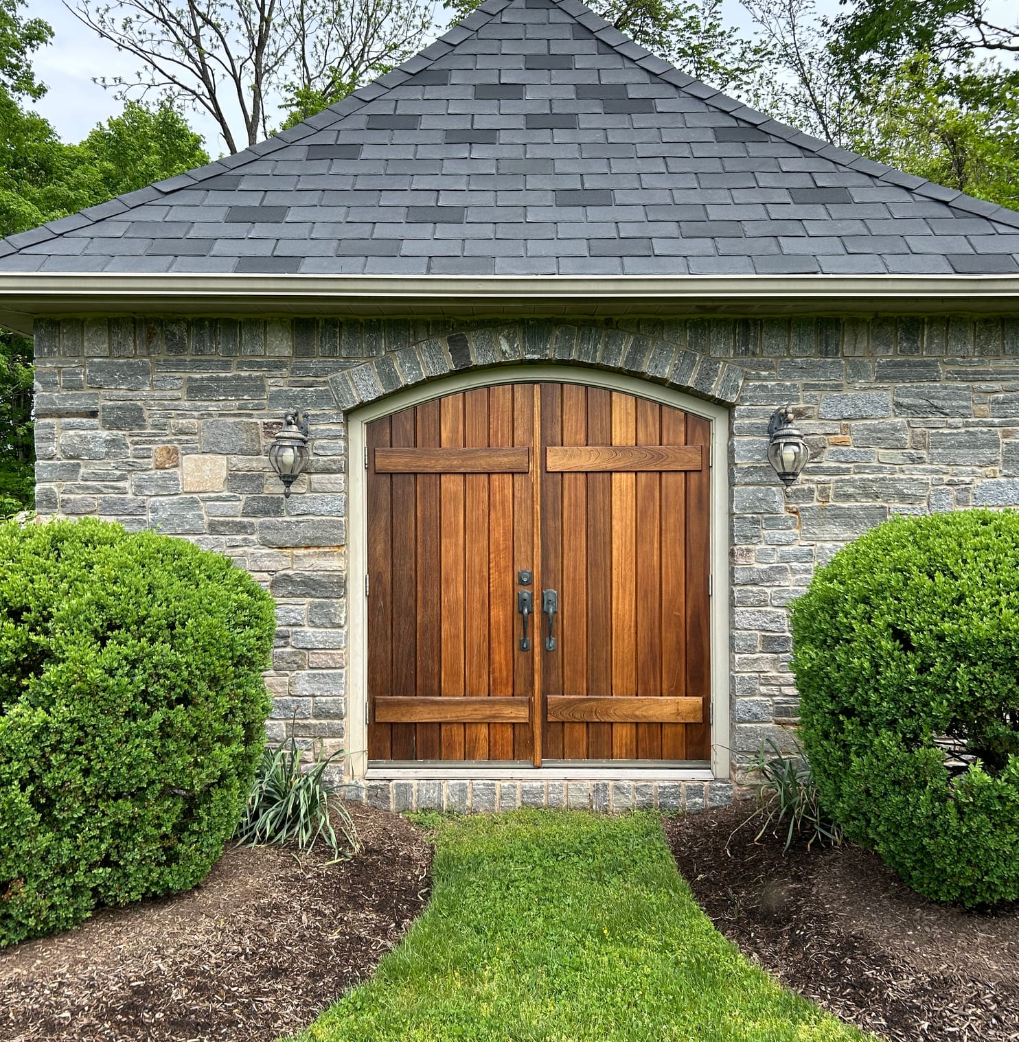 Stained wood doors on a stone pumphouse in Newtown