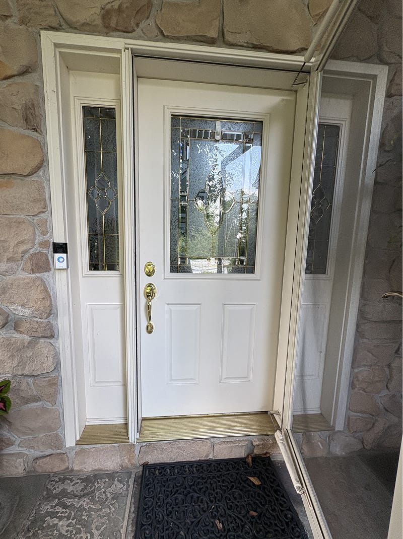 Exterior wood doors after staining — rich walnut finish on stone carriage house