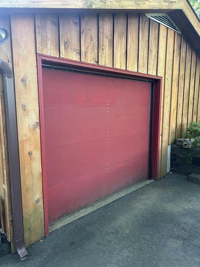 Exterior wood doors after staining — rich walnut finish on stone carriage house