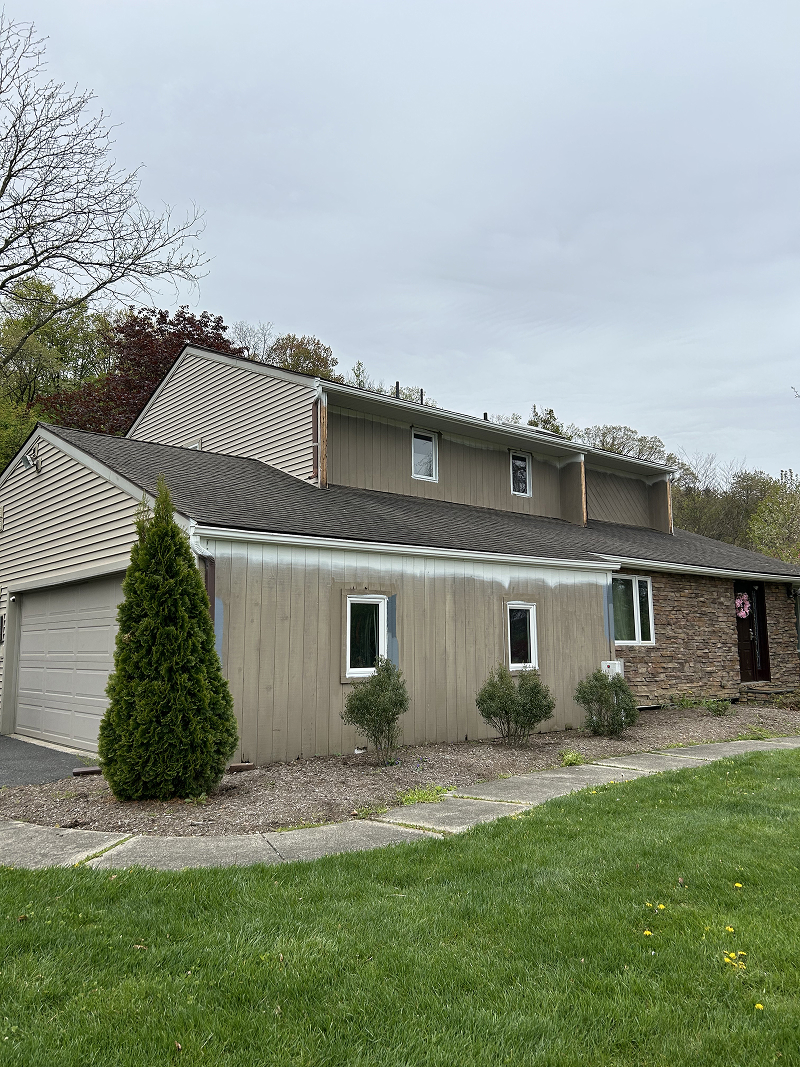 Exterior wood doors after staining — rich walnut finish on stone carriage house