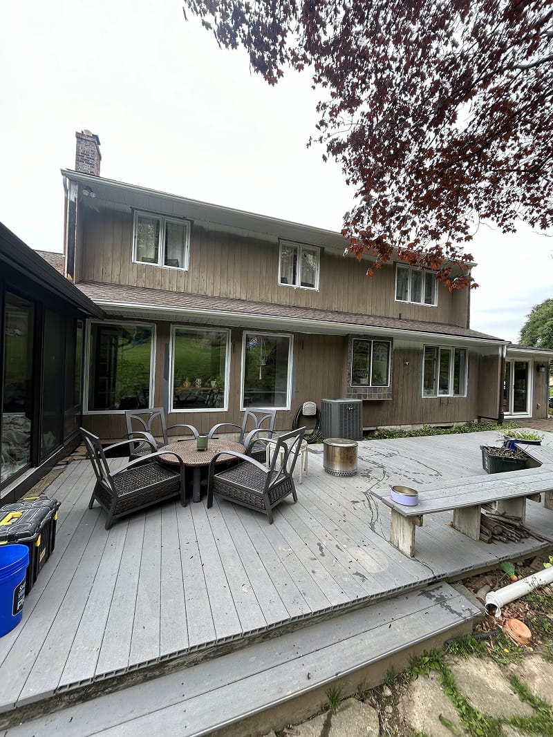 Exterior wood doors after staining — rich walnut finish on stone carriage house