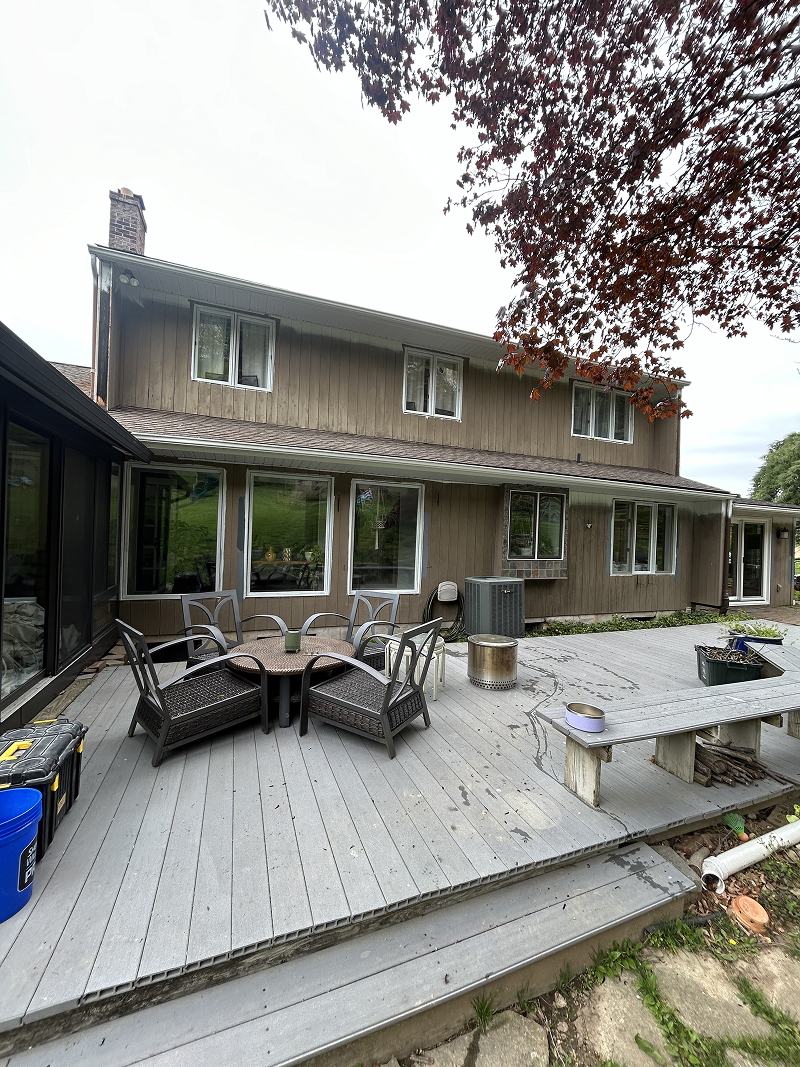Exterior wood doors after staining — rich walnut finish on stone carriage house