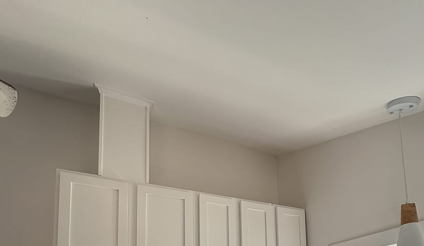 Kitchen cabinets painted white with the range hood boxed in